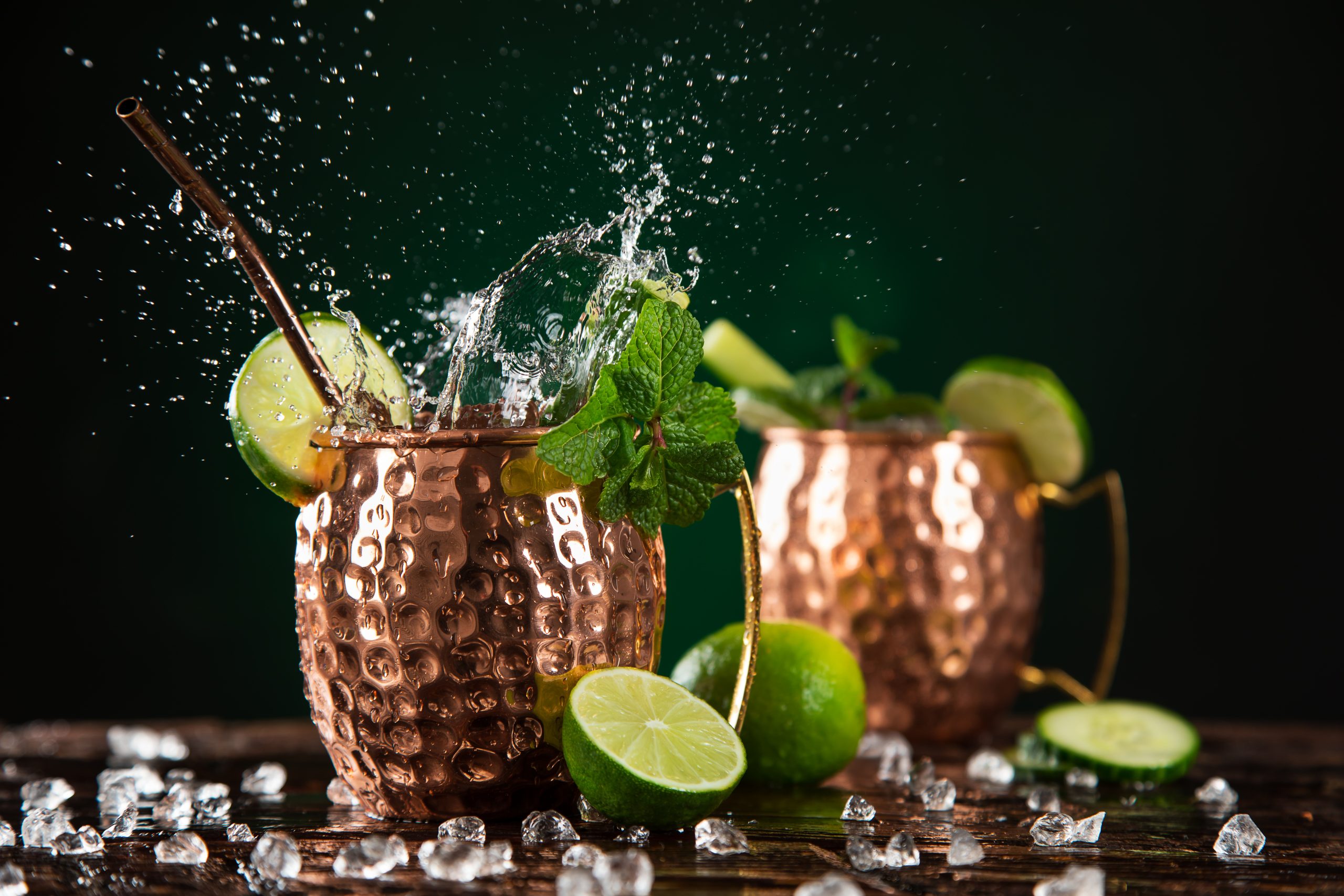 zwei Moscow Mule Cocktails in Kupferbechern mit Limetten, Minze und Eis