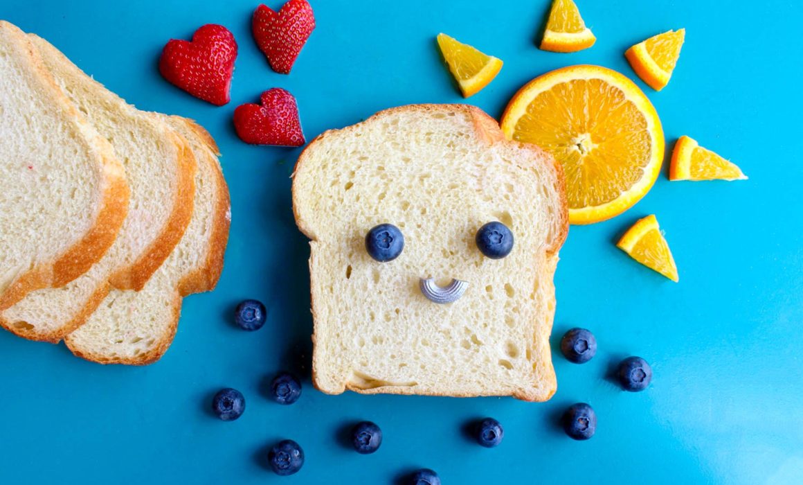 EIn Toastbrot mit Obst zu einem Bild gelegt als Haus mit Sonne und Erdbeeren als Rauch und Heidelbeeren als Fenster CC0 Sydney Troxell von Pexels